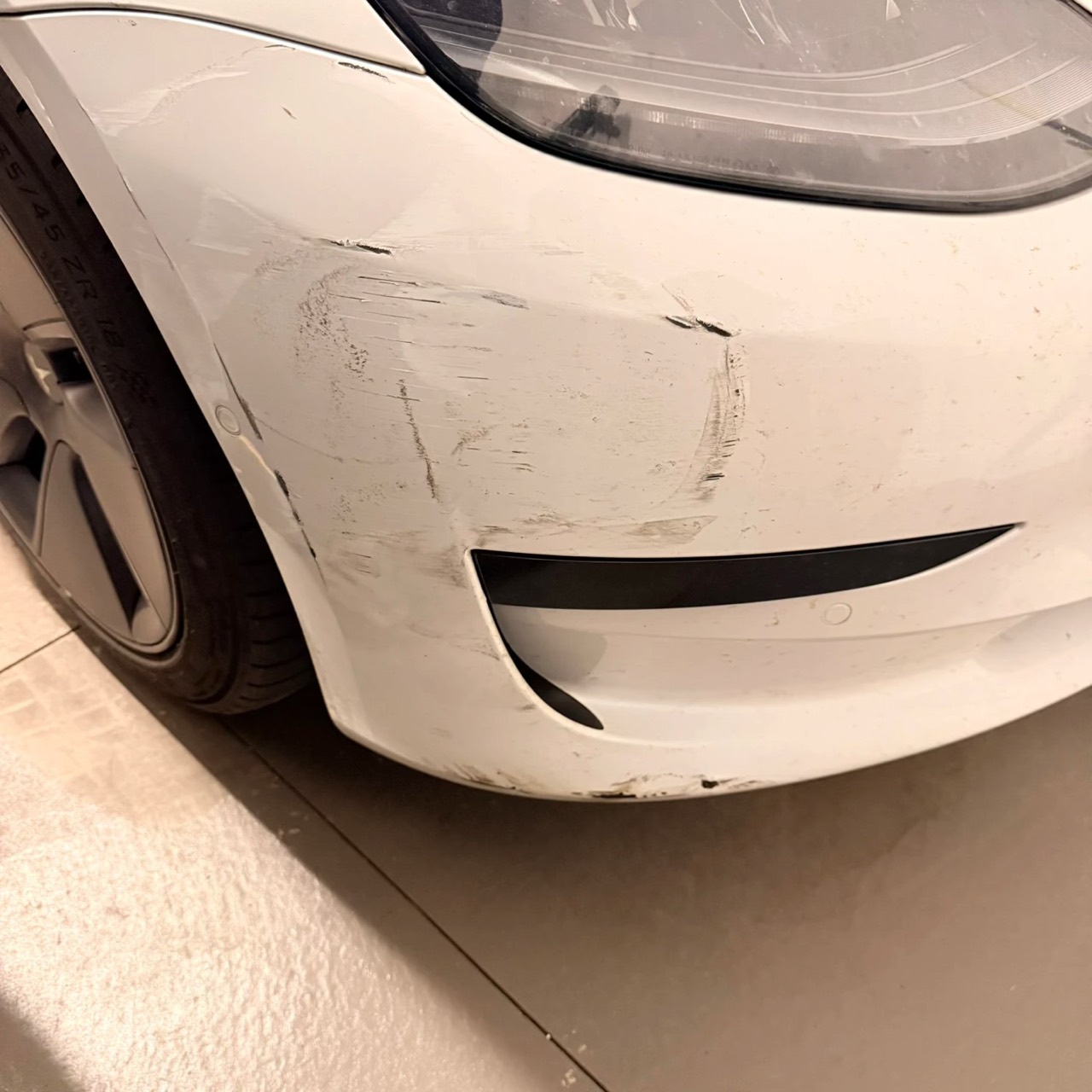 White Tesla front bumper before repair